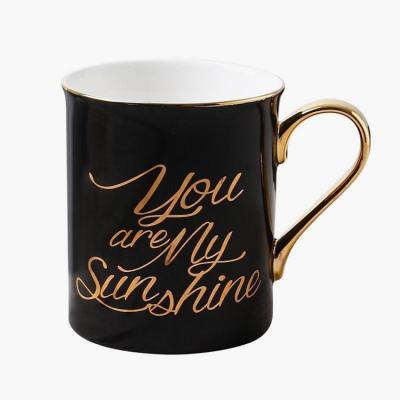 China Sustainable Luxury Style Letter Shape Cylinder Shape Gold Ceramic Black Mug With Logo for sale