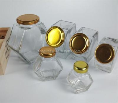 China Viable Design 50g 125g 250g 375g 500g 750g 1000g Fashion Design Honey Glass Bottle Hexagon Glass Jar With Metal Gold Lid for sale