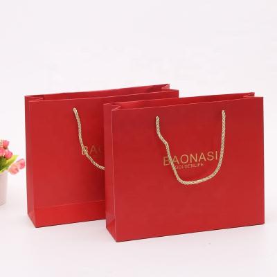 China New Logo Hot Foiled Stamping Black Matt Kraft Paper Bag With Gold Recyclable Cotton Rope Handles for sale