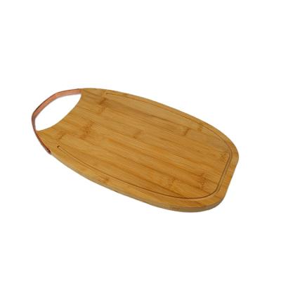 China Sustainable Wooden Kitchen Accessories Ellipse Organic Bamboo Cutting Board With Metal Handle for sale