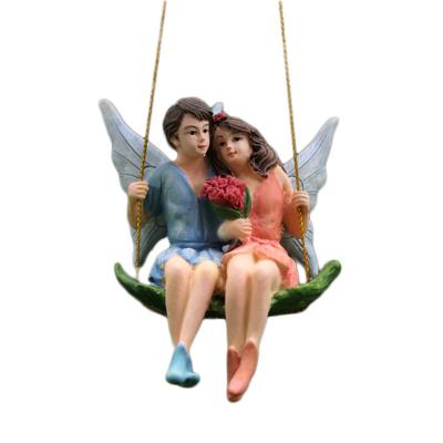 China New Europe Amazon Resin Figurnies Boy and Girl Sitting on Swing Miniature Fairy Garden Ornamen Home Decorative Statue for sale