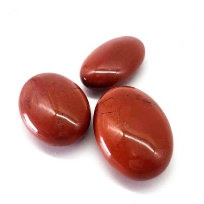 China Carving Fossil Wood Oval Red Jasper Crystal Palm Stones for sale