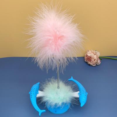 China 2021 Funny Teasing Windmill Stocked Toy Cat Dolphin Leaking Food Chewing Pet Amazon Cat Toy Turntable With Feather for sale