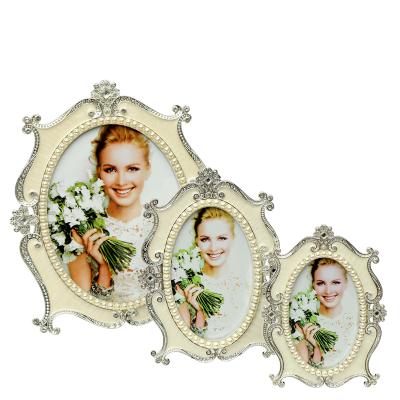 China Hot Selling European\Modern\Middle Eastern\African White Metal Rhinestone And Pearl Wedding Picture Frame European Style White Resin Frame for sale