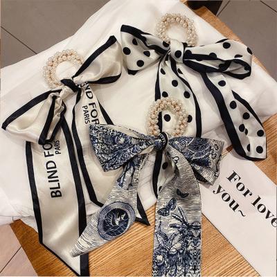 China Ribbon Tied Bow 2021 Sales Fashionable New Amazon Pearl Elastic Printed Silk Bow With A Girl's Hair Bands for sale