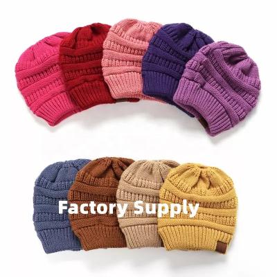 China COMMON Wholesale New Design Winter Beanie Multifunction Women Bun Ponytail Acrylic Beanie Hat With Hole for sale