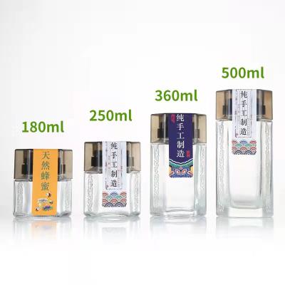 China Wholesale High Quality Minimalist Hexagon Honey Bottle Thickened Glass Sealed Jar Cut Out Storage Bottling for sale