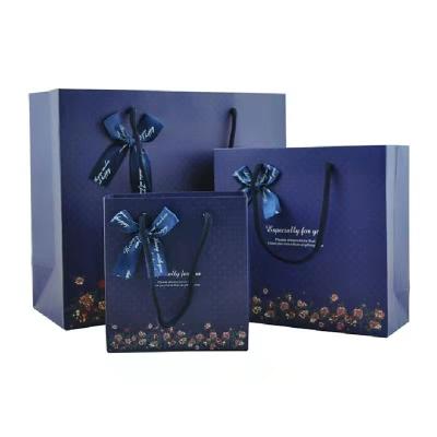 China Factory New Fashion Business Recyclable Wholesale Gift Bag Blue Apparel Handbag With Bow Ribbon for sale