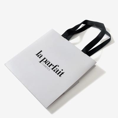 China Custom Handmade Logo Luxury Clothing Retail Bag White Gift Bag Shopping Packaging Paper Bags With Handles For Clothes for sale