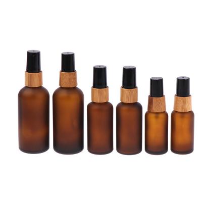 China Factory Wholesale Price Round Cosmetic 50ml 100ml Amber Frosted Glass Spray Bottle With Wooden Lid for sale