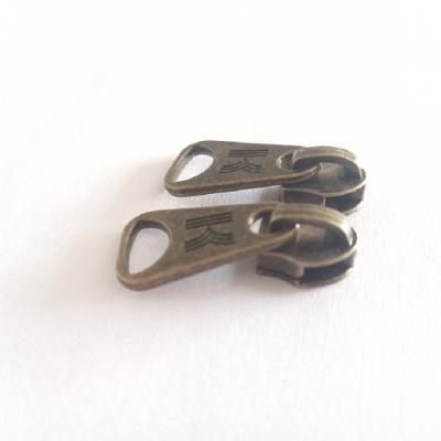 China 5# K popular logo nickel free metal zipper antique brass puller sliders point suitable for metal zipper for sale