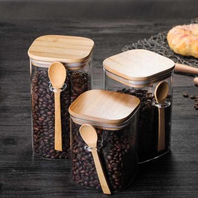 China Freshness Preservation Square Jar Household Coffee Bean Storage Glass Sealed Jar with Wooden Spoon Seasoning Bottle Kitchen Food Storage Jar for sale