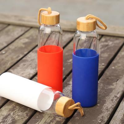 China Viable no MOQ bpa free custom logo custom glass water bottle with silicon bamboo lids and sleeve for sale