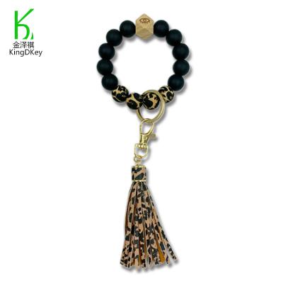 China New PU Leather Wooden Silicone Rubber Tassel Beaded Wristband Key Chain Leopard Printed Wrisyband Keychain for sale