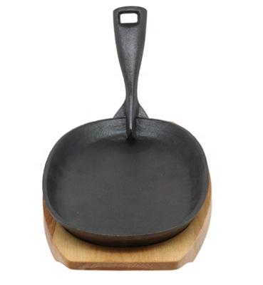 China Sustainable Cast Iron Oval Camping Sizzling Plate Steak Pan Barbecue Grill With Cast Iron Pull Out Handles And Wood Base for sale