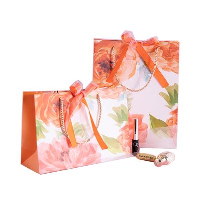 China Recyclable Wholesale Customized Beautiful Orange Chinese Rose Wedding Birthday Cosmetics Clothing Kraft Paper Bag Handle Shopping Gift Box for sale