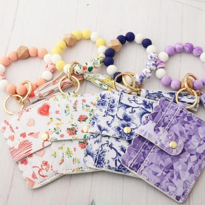 China Fashion Blue and White Leather Wallet Holder Ring Heart Floral Print Pu Tassel Ring Heart Key Bracelet Silicone Pearl Silicone Key Chain for sale