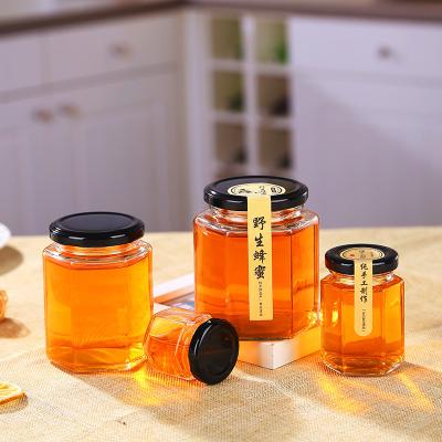 China Hexagon Honey Container In Stock Customized Size Transparent Glass Honey Jar Jam Bottle With Iron Lid Honey/Jam Packaging Manufacturer for sale