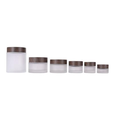 China Custom Empty Glass Face Lotion Cosmetic Containers Luxury Jar Frosted Cosmetic Cream Glass Jar With Gray Wood Grain Lids for sale