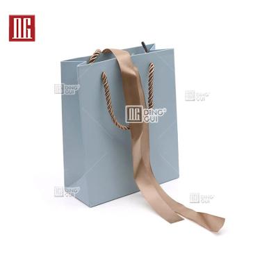 China Display Rings Custom DG Logo Paper Bag With Handles Showcase Personalized Logo By Foil Color Festival Gift Bags for sale