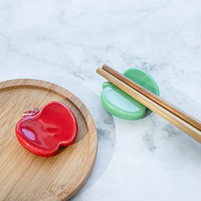 China Sustainable Reusable Red Ceramic Apple-Shape Porcelain Chopstick And Spoon Holder Dinnerware Chopstick Rest for sale