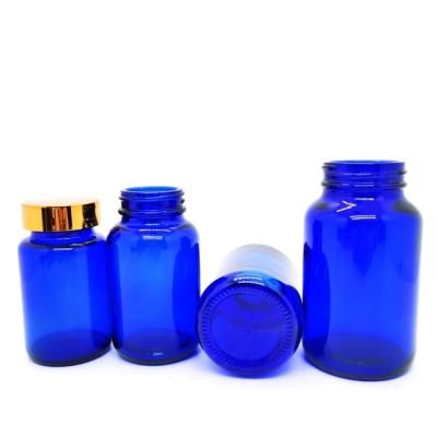 China 50ml 75ml 120ml Amber Wide Mouth Glass Jar Eco-friendly Cobalt Blue Pharmaceutical Glass Pill Bottles With Gold Aluminum Cap for sale