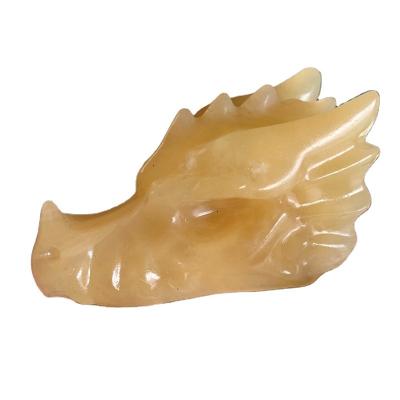 China Europe Dragon Head Skulls Polished Natural Orange Calcite Carved Statue for Home Decoration for sale