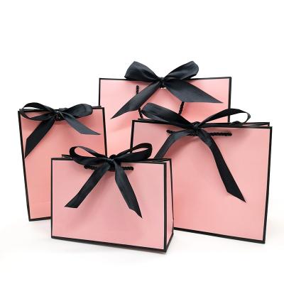 China Recyclable Pink Kraft Paper Gift Bag Bow Decoration Clothes Gift Wrapping Paper Hand Paper Bag for sale