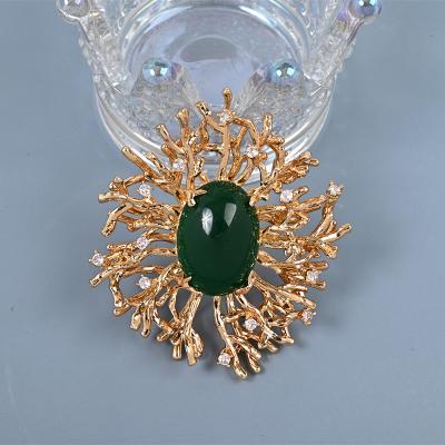 China Fashionable Retro gold plated emerald brooch with gemstone diamond hollow pattern designer brooches pins brooches for sale