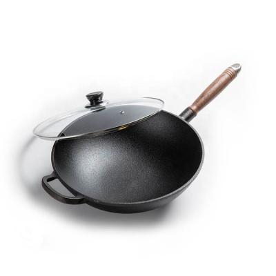 China Stron Sustainable Thai Cast Iron Cooking Wok Pan Non Stick Cast Iron Wok Pan with Wooden Handle and Glass Lid for sale