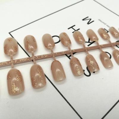 China 24pcs Design 24pcs Low Brownness Color Gold Foil UV Top Coat Shiny Artificial Nails With Glue for sale