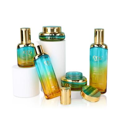 China Empty Gradient Color Cosmetic Luxury Multifunctional Skin Care Moisturize Lotion Glass Bottle Round Moisten Cream Jar Set for sale