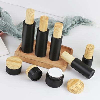 China 30ml 50ml 100ml Cosmetic Luxury Round Empty Face Lotion Cream Glass Bottle Jar Black Cosmetic Package Set With Spray Pump And Wood Grain for sale