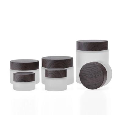 China 30g 50g Empty Frosted Cosmetic Skin Care Face Cream Glass Jar With Dark Wood Grain Lid for sale