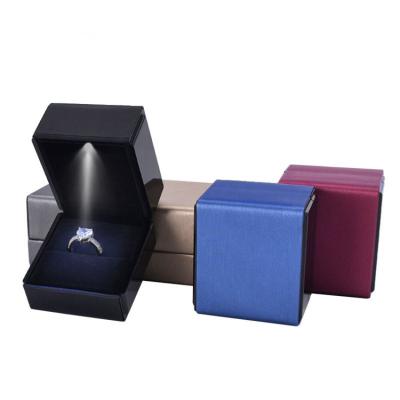 China Jewelry Packaging Box LED Lamp Proposal Ring Box Diamond Emerald Ring Display Brushed Leather Packing Case for sale