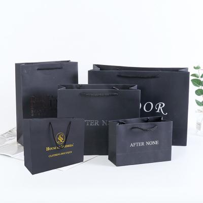 China Recycled Materials Black Printed Luxury Custom Paper Bag With Its Own Logo Apparel Shopping Bag Kraft Paper Suitcase for sale