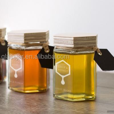 中国 45ml small hexagon shape glass honey jar with wooden lid 販売のため