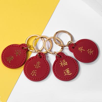 China Custom Red Genuine Leather Car Accessories 2022 New Year Logo Pu Leather Keychain Luxury Red Genuine Leather Key Chain for sale