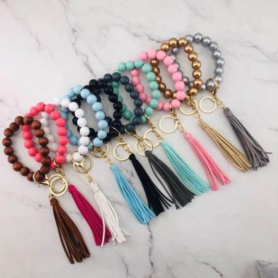 China CLASSIC Personalized Disc Suede Leather Key Chain Tassel Wood Tassel Key Bracelet Stretch Monogrammed Ring Wood Bead Bracelet With for sale