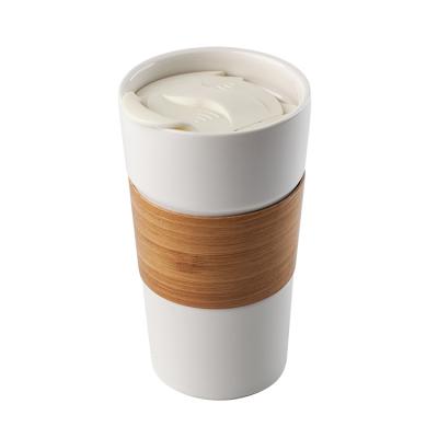 China Viable Custom Logo Bamboo Sleeve Ceramic Coffee Mug With Silicone Lid for sale