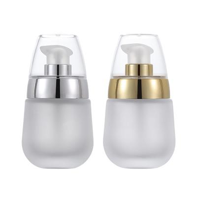 China Skin Care Glass Lotion Bottle With Silver And Gold Pump 30ml Oval Egg Shape for sale