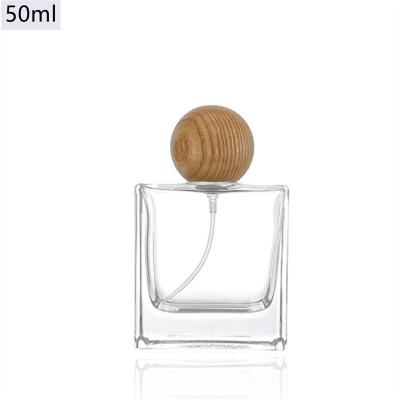 China Luxury Design 50ml Household Products Square Glass Empty Refillable Spray Lovely Perfume Bottle With Wooden Lid for sale