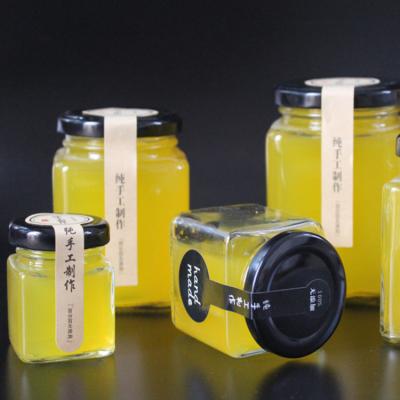 China Food Wholesale Different Sizes Food Grade Glass Jam Honey Jar With Black Lid for sale