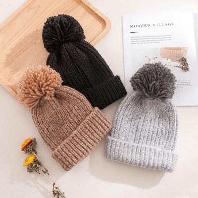 China COMMON Wholesale Chunky Cable Knit Faux Fuzzy Fur Pom Pom Winter Beanie Women Binnie Hat Knit for sale