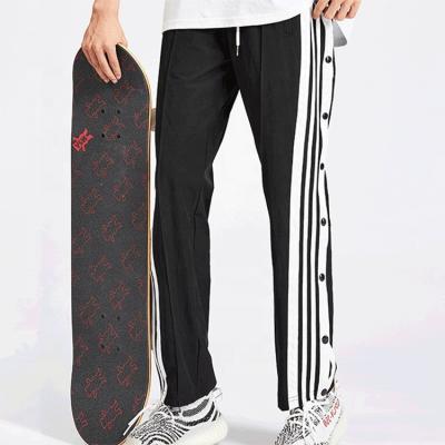 China Calças de pista de skate hip hop customizadas para homens com faixa lateral e botões à venda