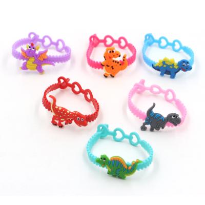 China Environmentally Friendly Cartoon Dinosaur PVC 3 Holes Soft Adjustable Rubber Wristbands for sale