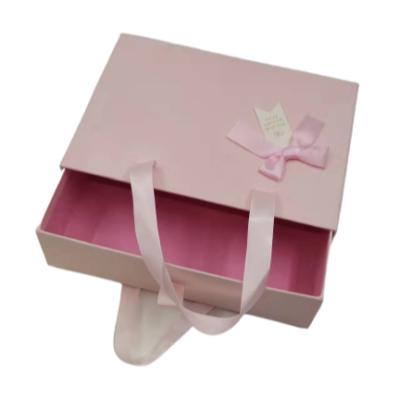 China Recyclable Pink Gift Box For Skirt With Bowknot Zipper Wholesale Small Handle Hard Paper Packaging Box for sale