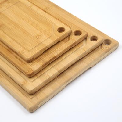 China Durable and sturdy organic bamboo cutting board with juice bowl, best sustainable for meat, vegetables and fruits for sale