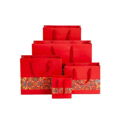 China Exquisite Custom Printed Luxury Ribbon Handle Portable Gift Bags With Company Logo for sale