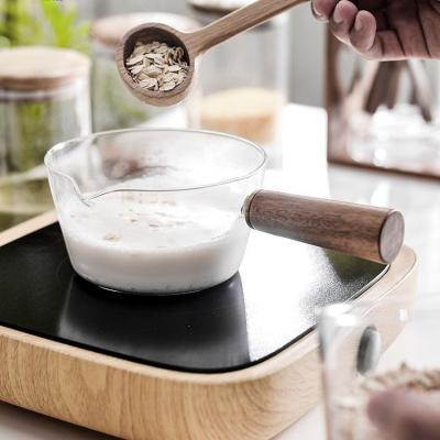 China Viable Clear Heat Resistant Glass Milk Pot Boiling Stew Pan Sauce Pot With Acacica Wood Handle for sale